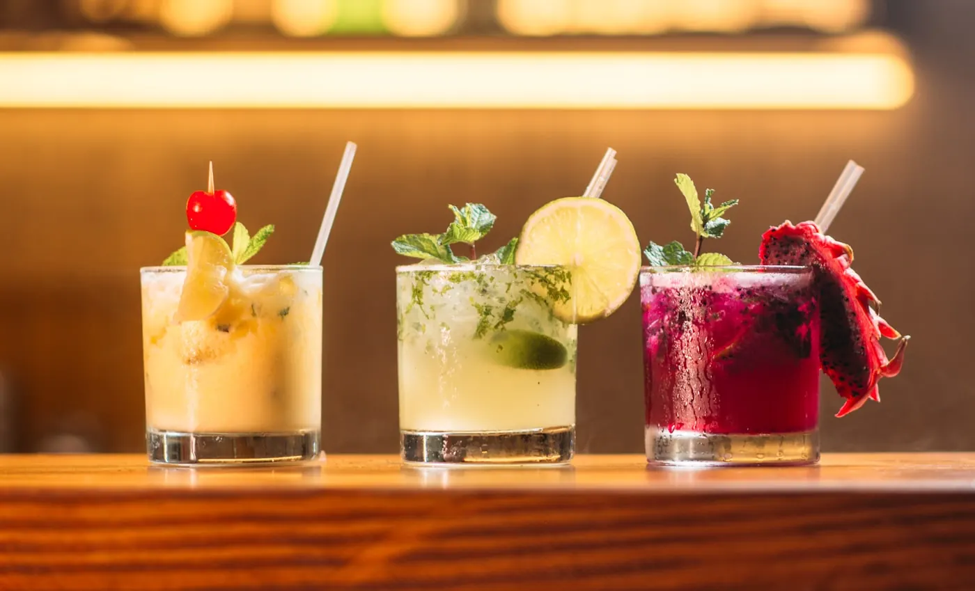 Barra de cocteles para eventos con bartender preparando bebidas